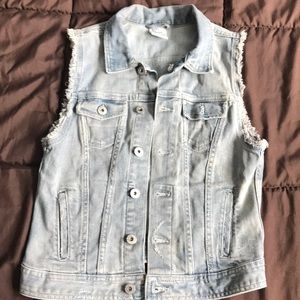 Denim vest with distressed sleeve details.